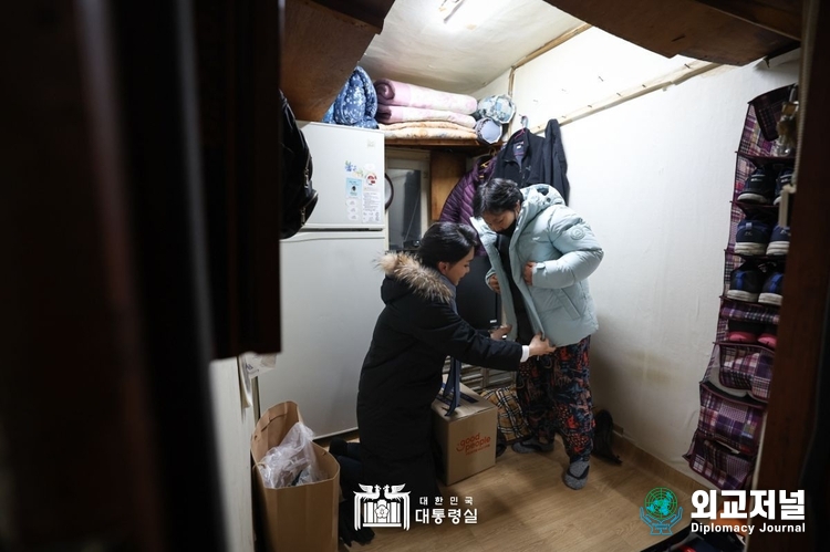 김건희 여사가 22일 찾아가는 성탄절 희망박스 나눔행사를 위해 서울 용산구 남대문쪽방촌을 찾아 어르신에게 겨울 점퍼와 목도리를 선물하고 있다. (대통령실=제공)