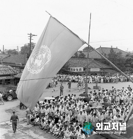  UN 한국위원회, 대구에서 열리다<br>
유엔 한국위원회가 대구에 있는 문화회관에서 전쟁발발 이후 첫 공식 모이을 개최했다. 강당에는 천명의 청중이 배석됐으며, 이것은 확성기를 통해 약 6천명의 군중에게 전달되었다.<br>
<br>
U.N COMMISSION ON KOREA MEETS IN TAEGU<br>
The United Nations Commission on Korea is holding its first public meeting since the outbreak of the war in the Cultural Hall at Taegu, An audience of one thous and is seated in the theatre. This is a partial view of the crowd of approximatly 6,000 listening outside to the proceedings over loud-speakers.<br>
Taegu, Korea, July 1950.