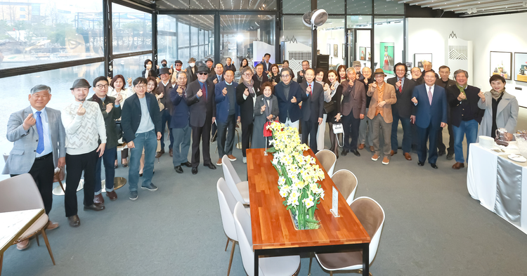 Artist Koo Chasoong poses with other artists, professors and guests at the opening ceremony for an exhibition of his art works.