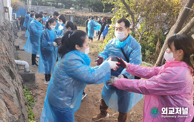 Chairman Lee Hyun-seok, along with his daughter Artist Lee Da-rae, volunteers to share love briquettes. 