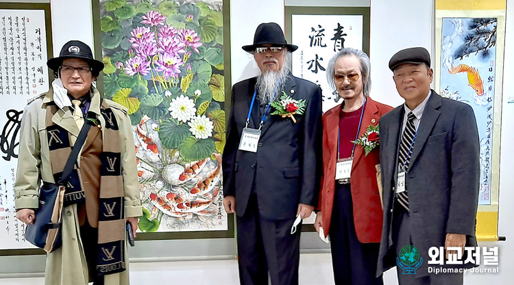 Painter Yoon Tae-yu poses for the camera with guests at an exhibition hall