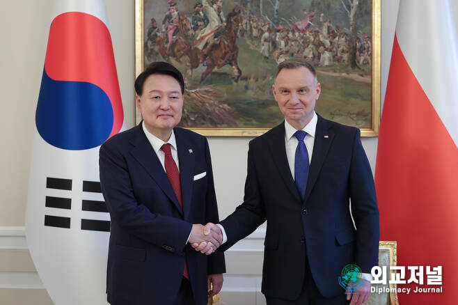 President Yoon Suk-yeol (left) shakes hands with Polish President Andrzej Duda before holding a summit at the Presidential Palace in Warsaw on July 13./ Courtesy of the Presidential Office