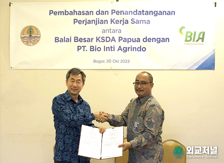 Hyun Chang-seop, CEO of POSCO International PT. BIA (left), and Athanasius Guntara Martana, Director of the Papua Environmental Protection Agency, shake hands after signing a business agreement.