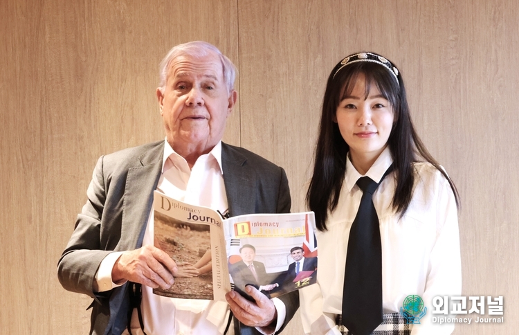 Chairman Jim Rogers (left) and Yuna Jung, executive secretary to Chairman Rogers, pose with the English monthly magazine, “Diplomacy Journal.”