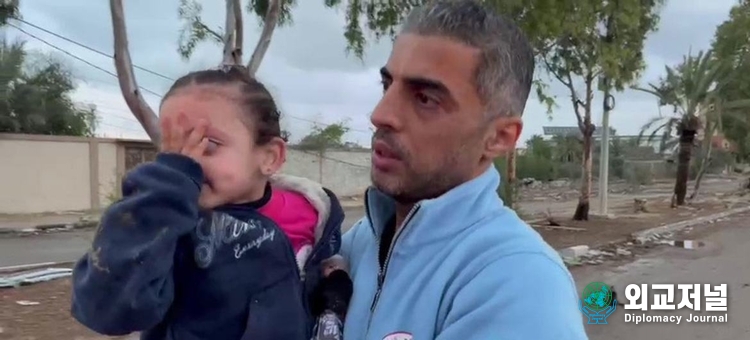Mouhammed, director of emergency and disaster management at the Palestinian Red Crescent Society (PRCS) in Gaza Strip, assists in receiving a displaced mother and two daughters after crossing a checkpoint heading to the south./ Courtesy of UN News
