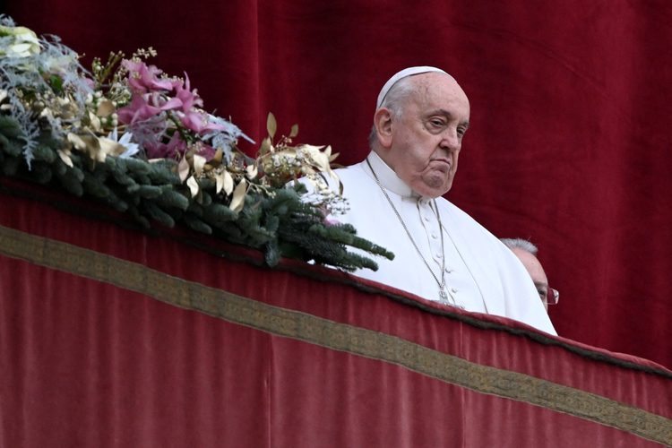 Pope Francis stands at the balcony of St. Peter's basilica to deliver the Christmas Urbi et Orbi blessing in St. Peter's Square at the Vatican on December 25, 2023.