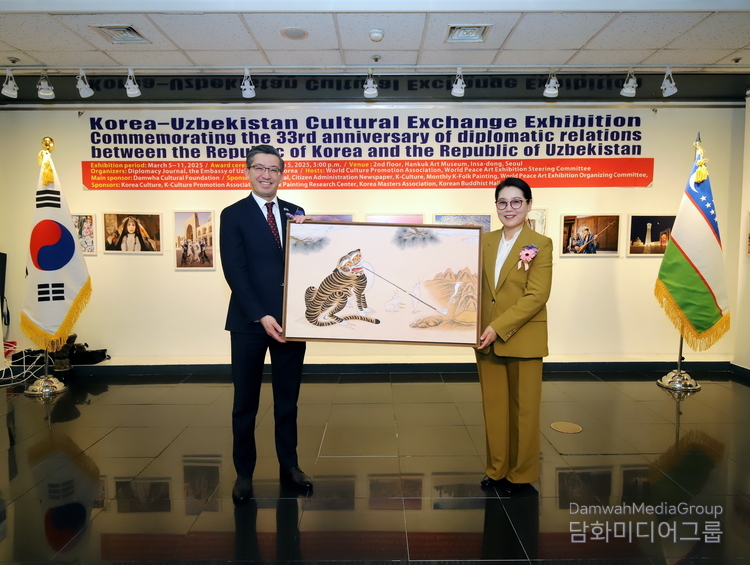 주한 우즈베키스탄 대사에게 이미형 명지대학교 교수(K-민화연구소장)이 작품을 기증하고 있다. 
