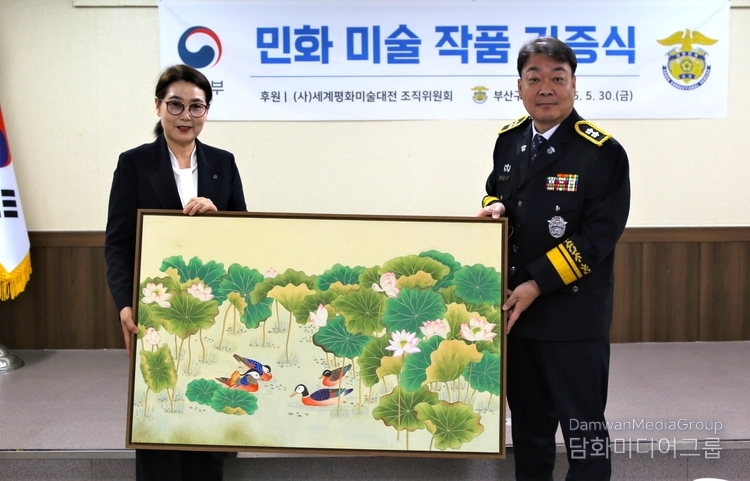 K-민화연구소 이미형 소장, 명지대 K-민화학과 교수(좌측)가 남준락 부신구치소장(우측)에게 전달하고 있다.
