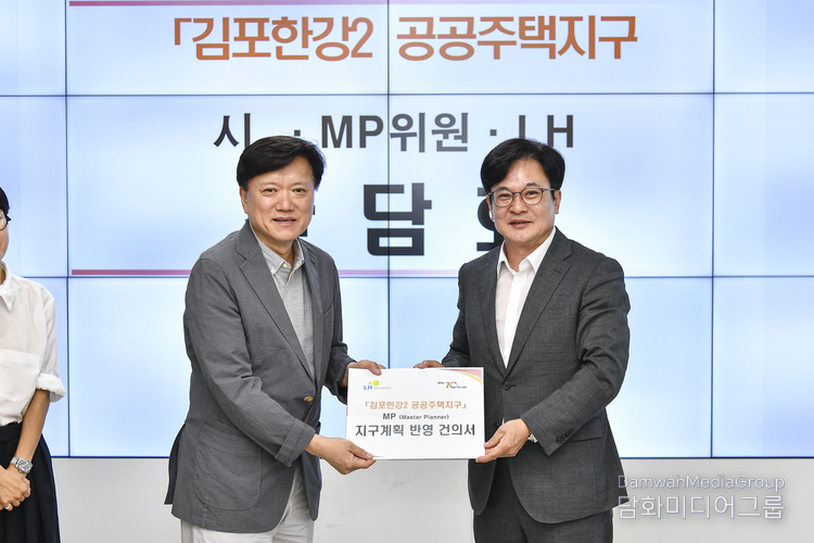 김병수 시장이 총괄계획(MP)위원장에게 지구계획반영 건의서를 전달했다.(사진-김포시)