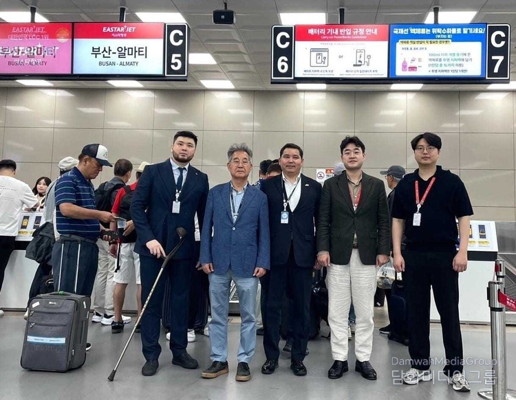 아슬란 아스카르 총영사, 이상훈 명예영사, 이스타항공 직원 및 카자흐스탄 총영사관 관계자들이 부산–알마티 노선 체크인 카운터 앞에 함께 서 있다.
