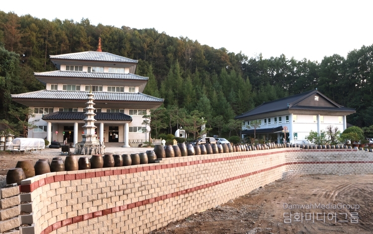 충북 청주시 상당구 미원면에 위치한 벽사초불정사僻邪招佛精舍(불정사) 전경. 이 사찰은 ‘악을 물리치고僻邪, 부처를 맞이한다招佛’는 뜻을 지닌 이름처럼, 세상의 번뇌를 치유하고 평화의 기운을 불러들이는 도량으로 조성되었다. 중앙의 본관 건물은 불교 박물관과 법당을 겸하고 있으며, 우측 건물에는 고승 친필과 유물, 그리고 K-민화 특별전시 공간이 마련되어 있다. 사찰 앞에는 항아리 담장과 석탑이 조화를 이루며, 평화·기도·예술이 어우러진 천년향화지지千年香火之地로 불린다.