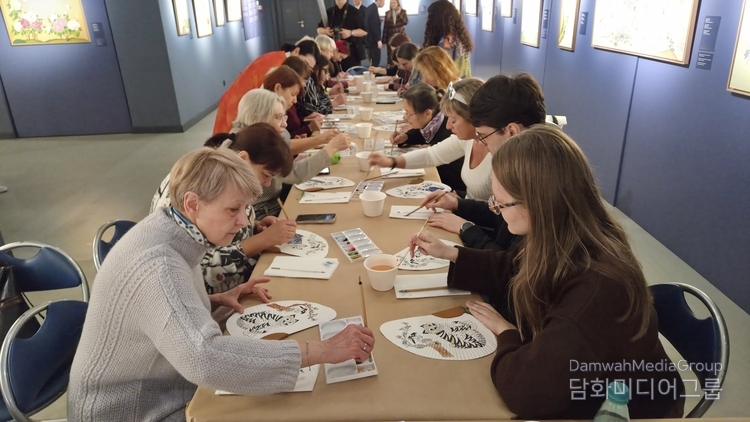 벨라루스 국립미술관에서 열린 한국 전통 민화 마스터클래스 참가자들이 한지 부채에 호랑이 문양을 채색하며 민화 기법을 체험하고 있다. 이번 체험은 명지대학교 이미형 교수가 직접 지도했으며, 참가자들은 한국의 전통 색채와 상징 표현을 배우며 큰 관심을 보였다.