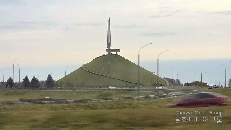 벨라루스 민스크 인근에 위치한 영광의 언덕(Mound of Glory, Курган Славы). 이 기념비는 제2차 세계대전 당시 나치 독일로부터 벨라루스를 해방시킨 전투를 기리기 위해 1969년에 세워졌다. 거대한 인공 언덕 위로 네 개의 창 모양 구조물이 솟아오르며, 이는 전선에서 싸운 4개 소련 전선을 상징한다. 언덕을 따라 나선형으로 이어진 길은 해방의 여정을 의미하며, 정상에 오르면 벨라루스의 평원과 민스크 시내가 한눈에 내려다보인다. 전쟁의 상흔 속에서도 평화와 자유를 향한 인류의 염원을 상징하는, 벨라루스의 대표적 역사 기념지이다.(사진-담화미디어그룹)
