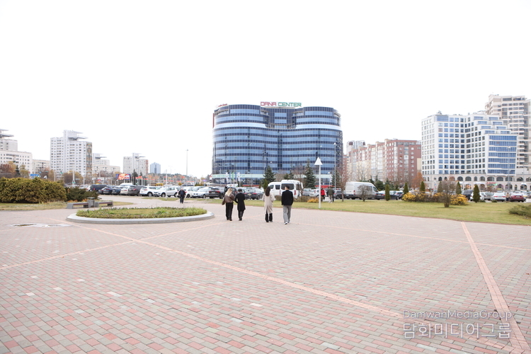 벨라루스 민스크 국립도서관 앞 광장의 전경. 도서관을 등지고 바라본 도심 풍경에는 현대식 빌딩과 상업시설이 조화를 이루며, 중앙에 자리한 둥근 광장이 시민들의 산책로와 휴식 공간으로 활용되고 있다. 도심 속에서도 여유와 질서가 느껴지는 민스크의 일상 풍경이 고요하게 펼쳐진다.(사진-최동호 국장)