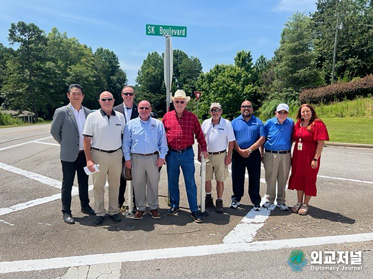 &nbsp;SK and Georgia officials take commemorative photo in front of the road sign. / Courtesy of SK On